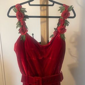 Formal red velvet midi dress with roses on straps.